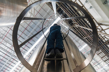 The male worker down the ladder is for inspection stainless steel tank chemical. © chitsanupong