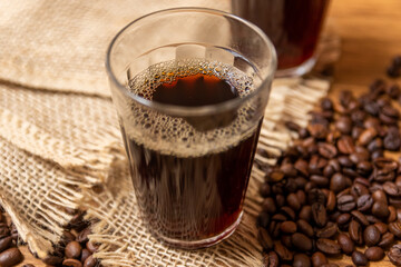 Cup of coffee in American glass, Typical Breakfast in brazil. With coffee beans on the background