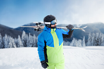 Portrait of a skier in the ski resort on the background of mountains and blue sky, Bukovel. Ski...
