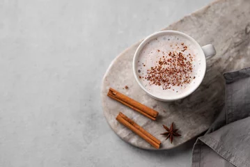 Deurstickers White mug of hot cocoa or chocolate with whipped cream, cinnamon sticks and star anise on a gray background. © Kufotos