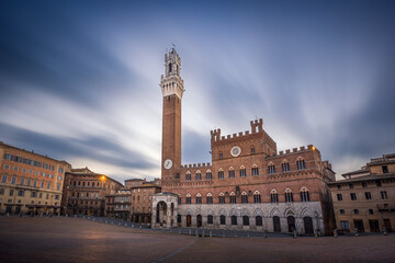 Medieval Palazzo Pubblico with Torre del Mangia tower on empty Piazza del Campo square, Siena, Italy