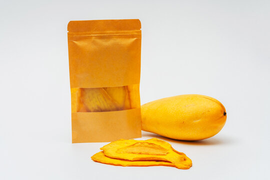 dried mango slices in a bag on a white background. dehydrator-dried mango for cooking and drinking. mango chips in a pack on a light background