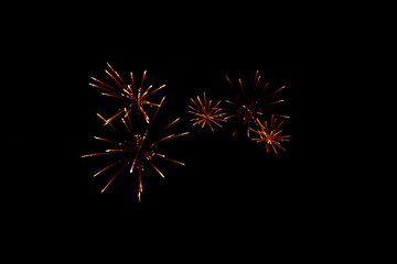 Fireworks explosions with Golden colors over a party in the black night sky.