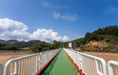 Puente Pobeña bridge over the river Barbadun seen from Playa La Arena beach under a blue sky, Pobeña, Basque country, Spain