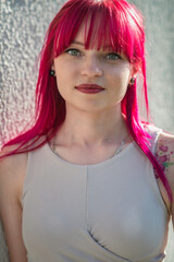 Portrait of a young beautiful girl with red hair in an urban environment.