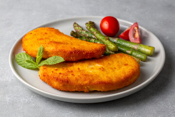 Cordon bleu served with asparagus.