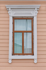 Typical timber window with carved architraves facade of 19th century residential building, Russia