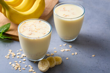 Vegan banana and oatmeal smoothie in glass jar on light background. Healthy foods.