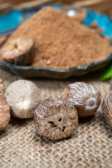 Fototapeta premium Tasty winter spice whole dried and ground powder nutmeg, used as an ingredient in many dishes, eggnog, potato, mulled wine