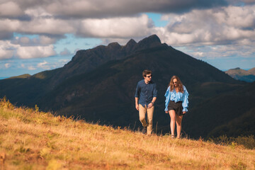 Young stylish couple walking along the mountain