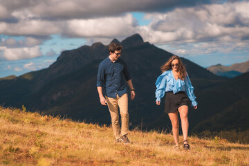 Fototapeta na wymiar Stylish casual couple walking distracted in the mountain