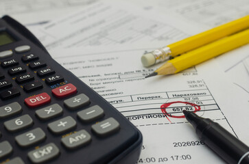 Financial accounting with calculator and credentials and marker, close-up