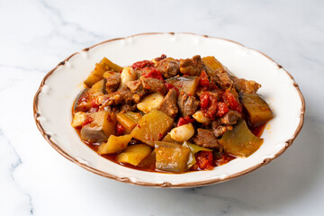 Top view of Turkish dish Guvech - baked meat with eggplant and traditionally served in earthenware pot (Turkish name; etli patlican guvec or patlican tava)