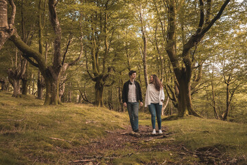Fototapeta premium Lovers holding hands and walking in the forest