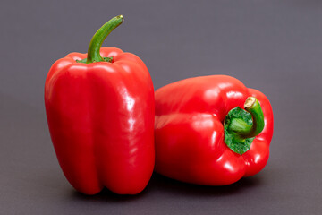 Two Fresh Red Sweet Bell Peppers on Black Background