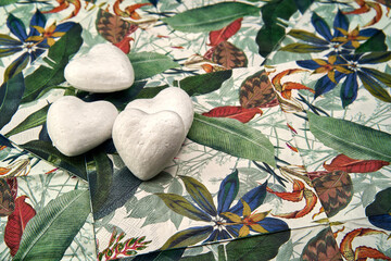 White hearts representing the purity of love on a tropical patterned background.