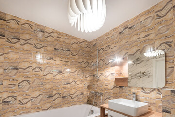 Modern design of the bathroom, decorated with tiles with a pattern of natural stone. .Stylish...