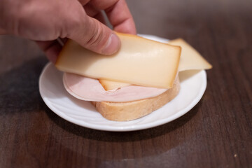 Making a sandwich with sausage and cheese