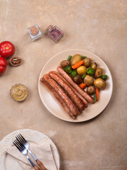Chicken sausages with a side dish of new potatoes and vegetables