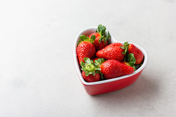 Fresh strawberries in heart bowl with copy space