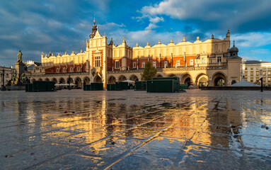 Renaissance Cloth Hall on Krakow Main Square reflecting in the wet cobblestones, sunny morning, Cracow, Poland