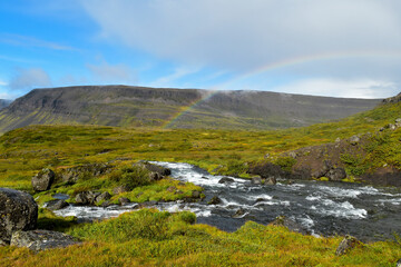 Fototapeta na wymiar A rainbow arcs over the Iceland landscape after a heavy rain.