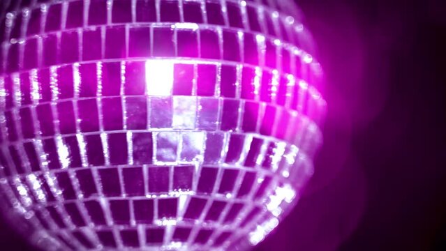 Pink disco ball. DISCO LIGHTS. The footage of a disco ball on pink lights background. 