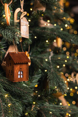 decorations on the Christmas tree close-up. vintage house on a branch and numerous bokeh.