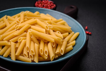 Raw penne pasta from whole grain wheat varieties with salt and spices