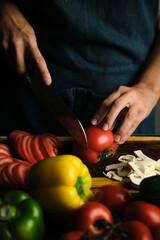 close-up of the cook's hands slicing tomatoes