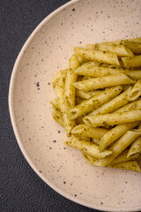Delicious fresh pasta penne with green pesto sauce with basil, salt and spices