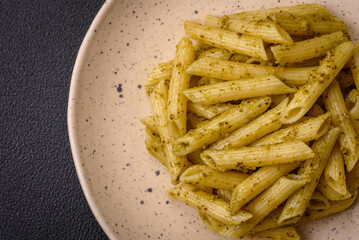 Delicious fresh pasta penne with green pesto sauce with basil, salt and spices