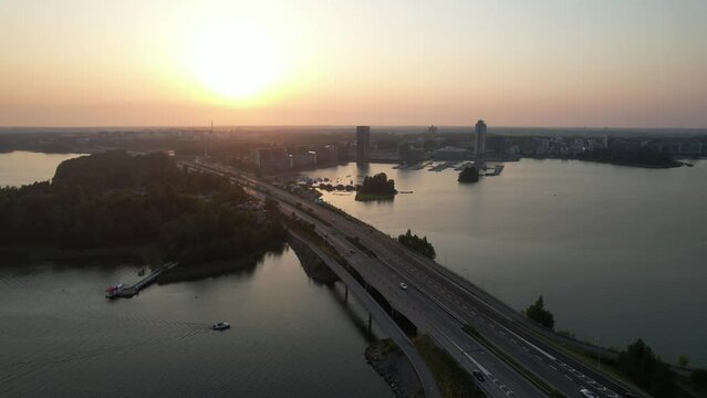 Reverse aerial flight along a highway into the sunset
