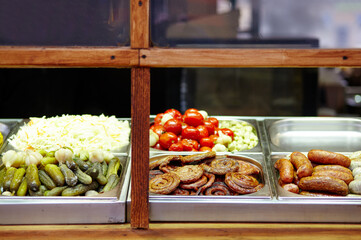 Christmas street food festival on fair in town center, winter holidays. Bbq street food for sale, delicious sausages on holiday street market in european city