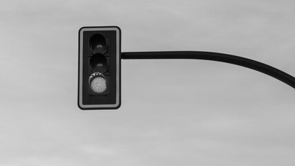 Semáforo regulador de tráfico sobre una carretera en blanco y negro