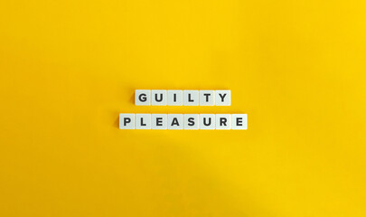 Guilty Pleasure Phrase on Block Letter Tiles on Yellow Background. Minimal Aesthetic.