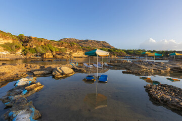 A picturesque bay on the island of Rhodes with shallow water that forms small lagoons between the...