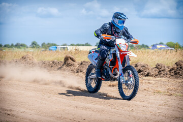 Fototapeta na wymiar Enduro bike racer riding on dirt motocross road