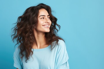 Fototapeta premium Beautiful happy woman on blue background looking to the side