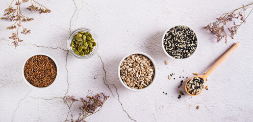 Sesame, flax, pumpkin and sunflower seeds in bowls for women's health top view web banner - obrazy, fototapety, plakaty