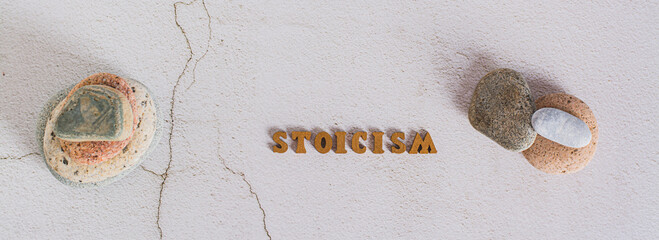 Concept stoicism word made from letters and stones on gray background top view web banner