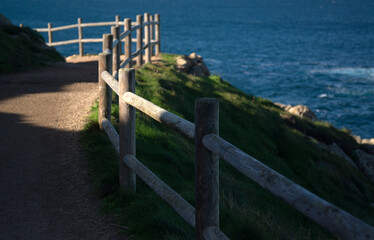 Wooden fence in perspective on the blue sea shore - 684338023