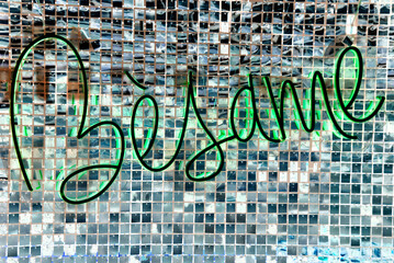 Love lettering on a mosaic background. 
Neon sign in the window of a cafe at night, Spanish