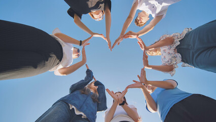 School children make a heart shape from their hands. - Powered by Adobe