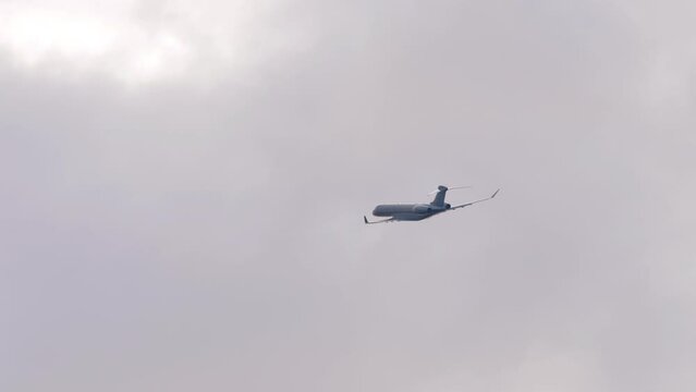 Long shot, small jet passenger plane with an unrecognizable livery is flying, side view. Passsenger plane in the sky