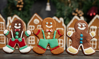 Decorated gingerbread houses christmas cookies with christmas wreath on dark table