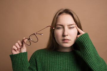 woman with poor vision on a isolated beige background, health problems astigmatism myopia, Poor...