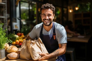 Cheerful Caucasian male bakery owner or employee holding freshly baked wheat bread loaves packed in craft paper bags. High-quality and fresh products from small businesses in the food industry.