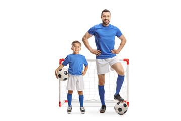 Man and boy with football wearing same sports jersey in front of a mini goal