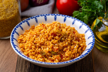 Traditional turkish bulgur pilaf with tomato sause in plate (Turkish name; meyhane pilavi)